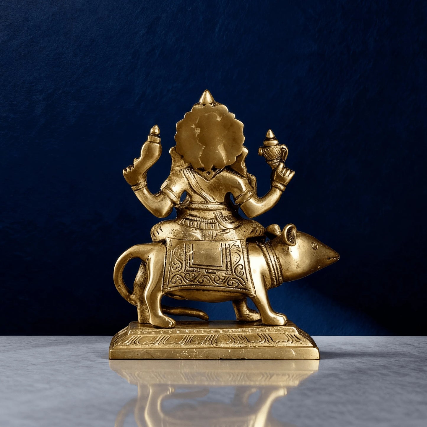 Back view of brass Ganesha riding mouse statue showing engraved details