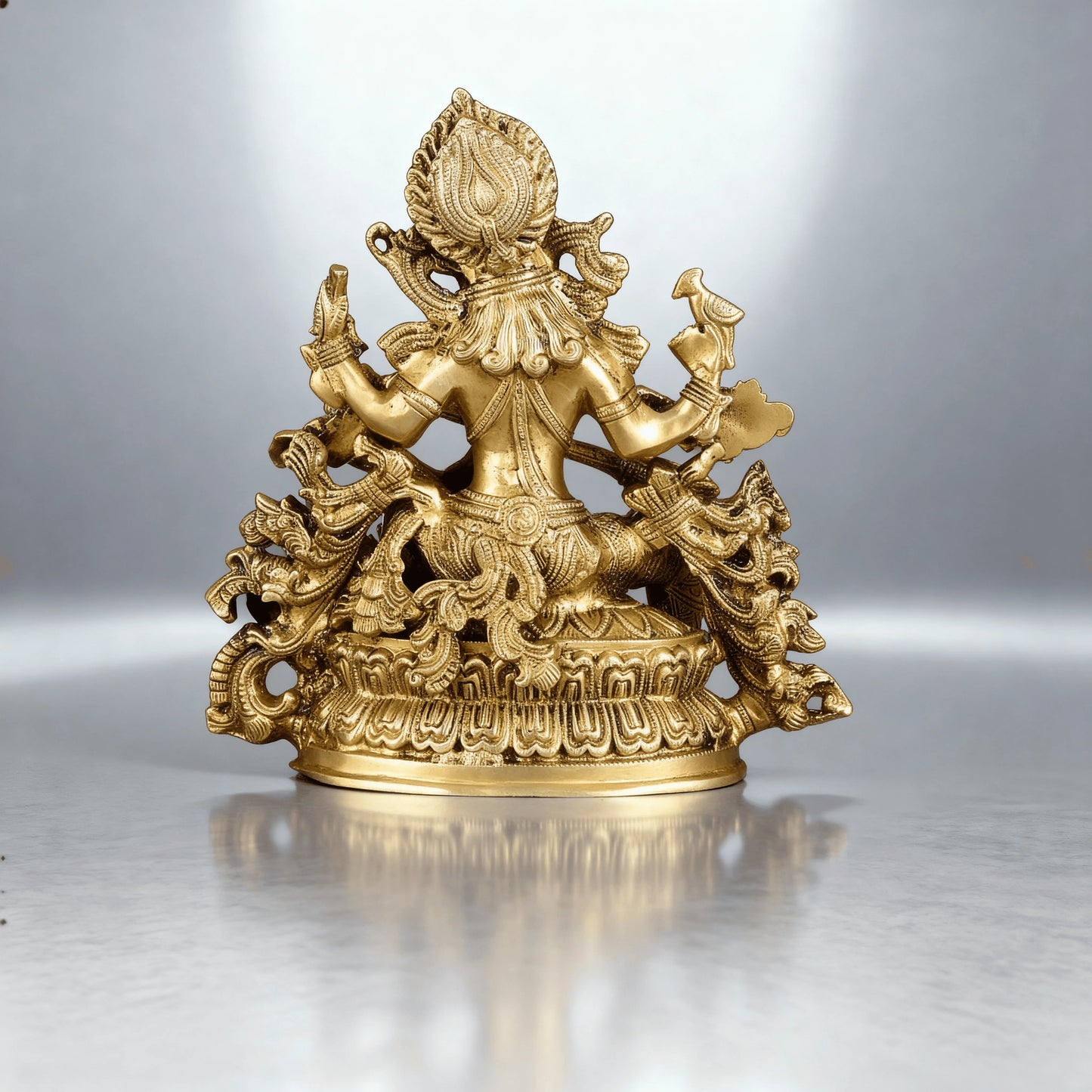 rear view of brass Saraswati sculpture showing detailed back carvings, hair design, and ornate base work