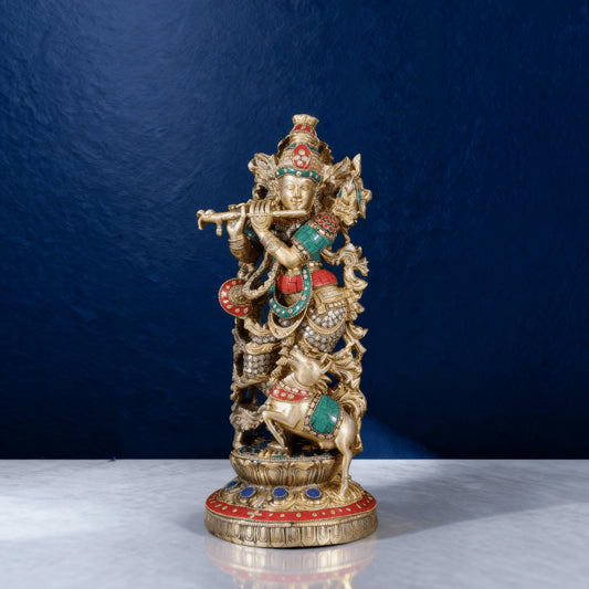 Intricately handcrafted brass Lord Krishna statue with flute and jumping cow, detailed in green, red and blue enamel work – front angle