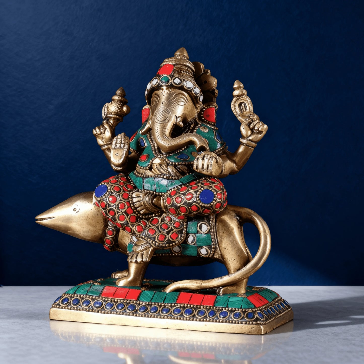 Close angle brass Ganesha idol on mouse vahana with intricate stone inlay and traditional finish
