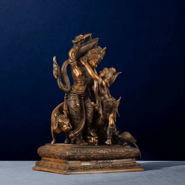 Side-angle view of brown brass Krishna lifting Govardhan idol with cow and peacock motifs, intricate detailing for luxury home decor.