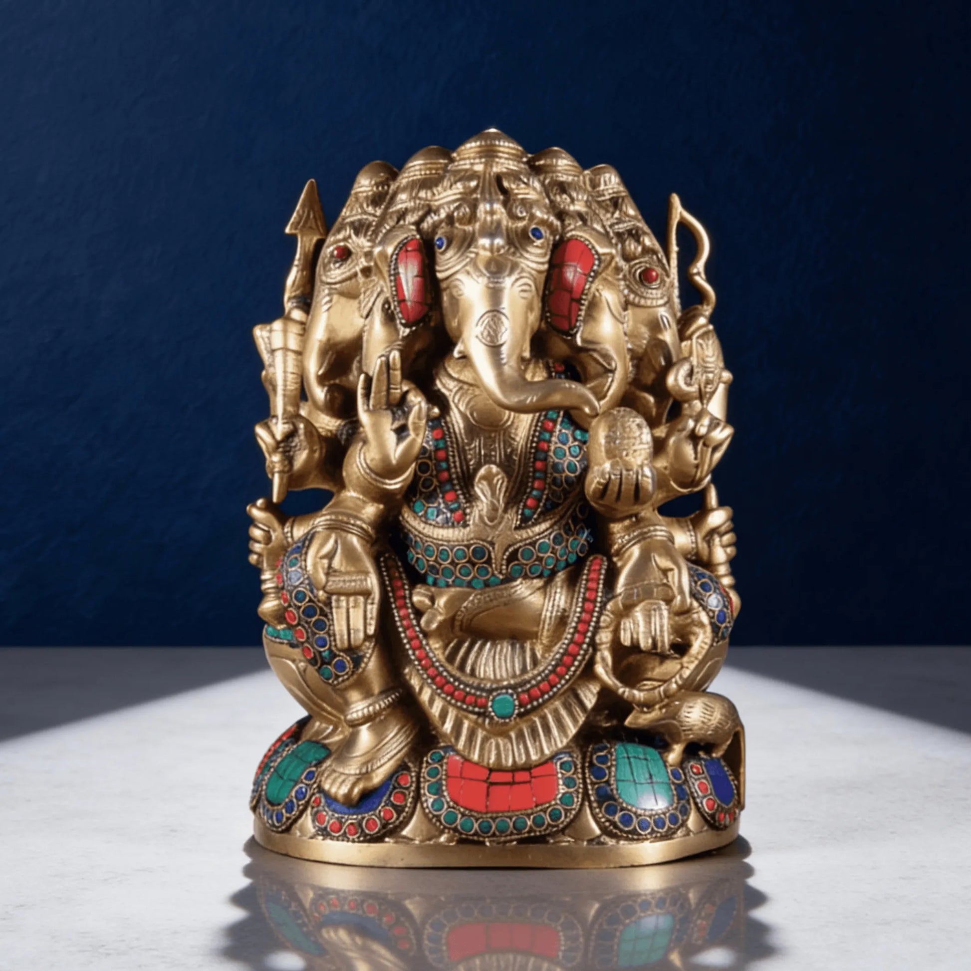 front angled view of brass ganesha idol with colorful stone detailing