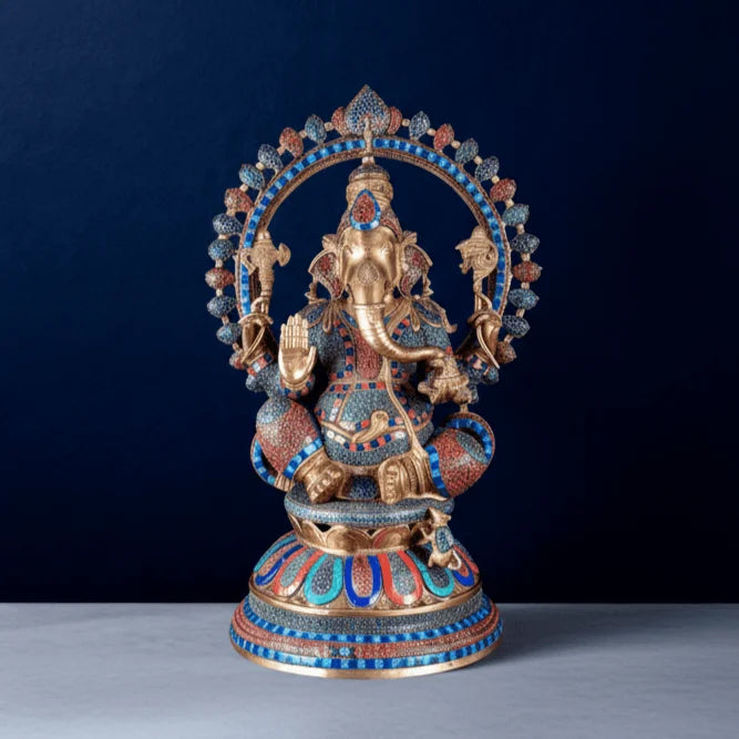 Pure brass Ganesha statue with colorful meenakari stonework and detailed halo on a dark blue studio background