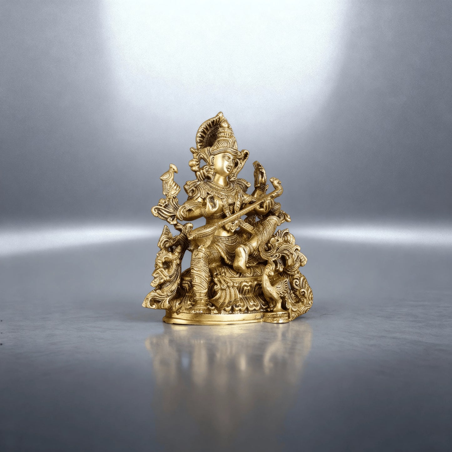 brass Saraswati idol photographed in a studio setup with soft lighting, showing detailed carving and balanced posture