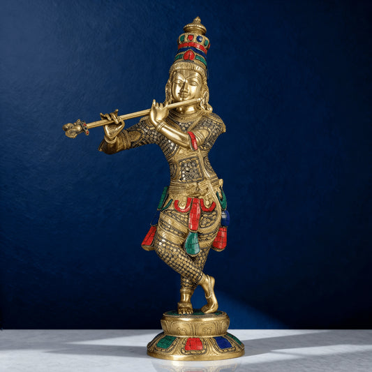 Side angle of brass Krishna idol with vibrant red green blue stone inlay