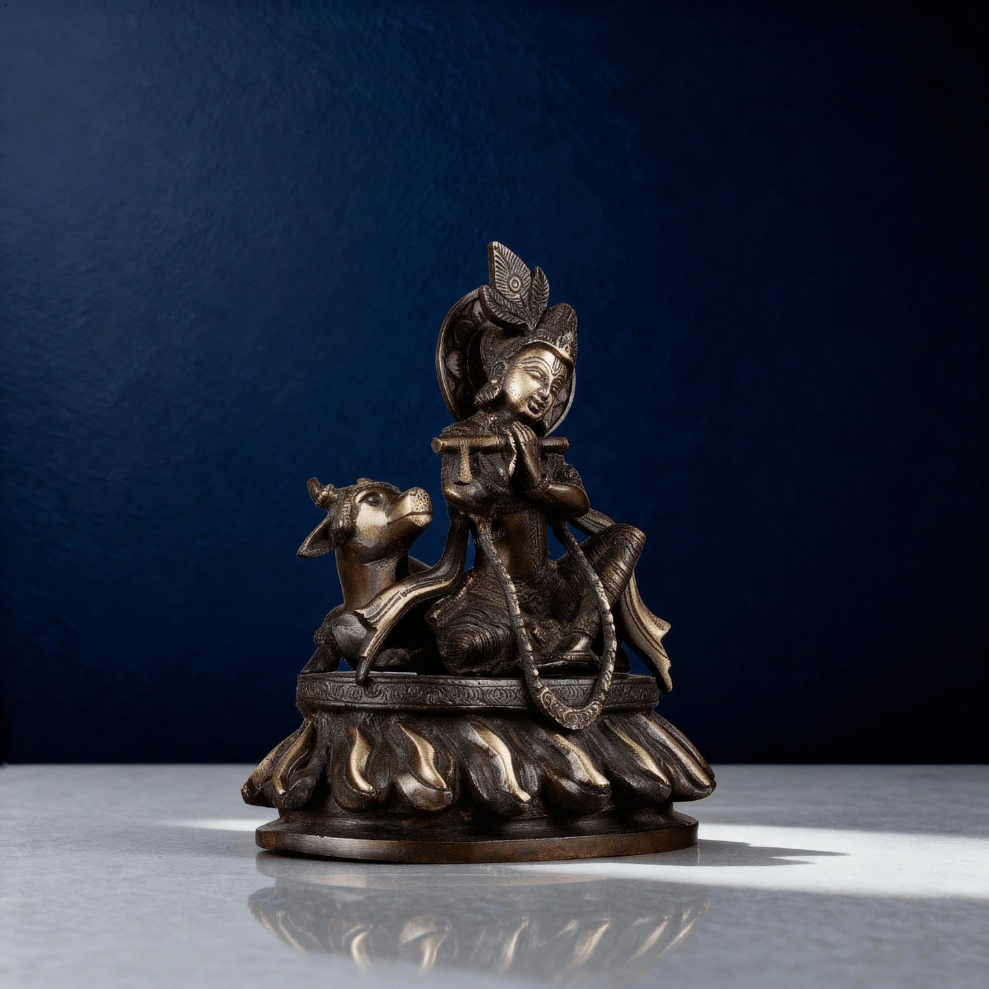 Handcrafted brass idol of Krishna seated with cow on flame base, antique finish, premium Indian metal art decor