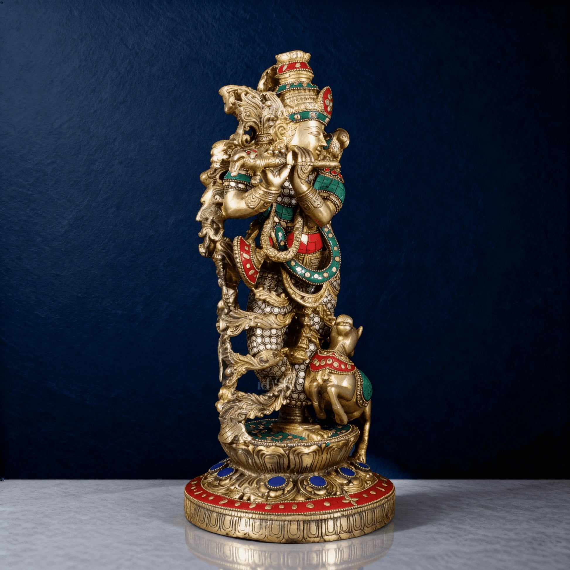 Detailed side angle of pure brass Krishna with cow sculpture, showcasing vibrant red and green gemstone accents and fine engravings
