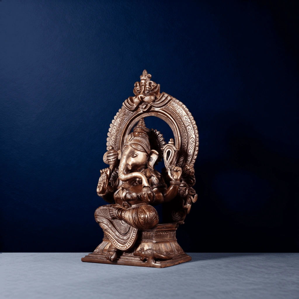 Side-angle view of brass Ganesha statue seated under ornate arch with detailed carvings for home decor
