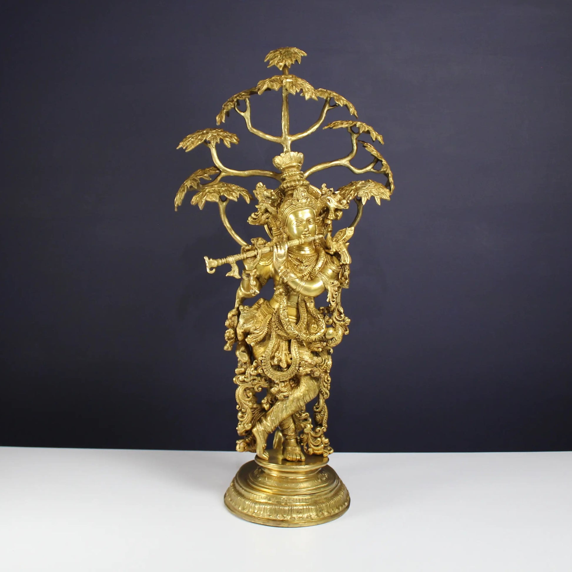 Brass Krishna statue under Tree