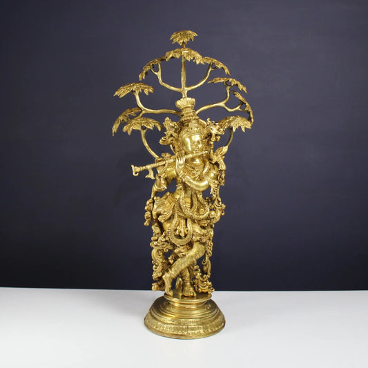 Brass Krishna statue under Tree