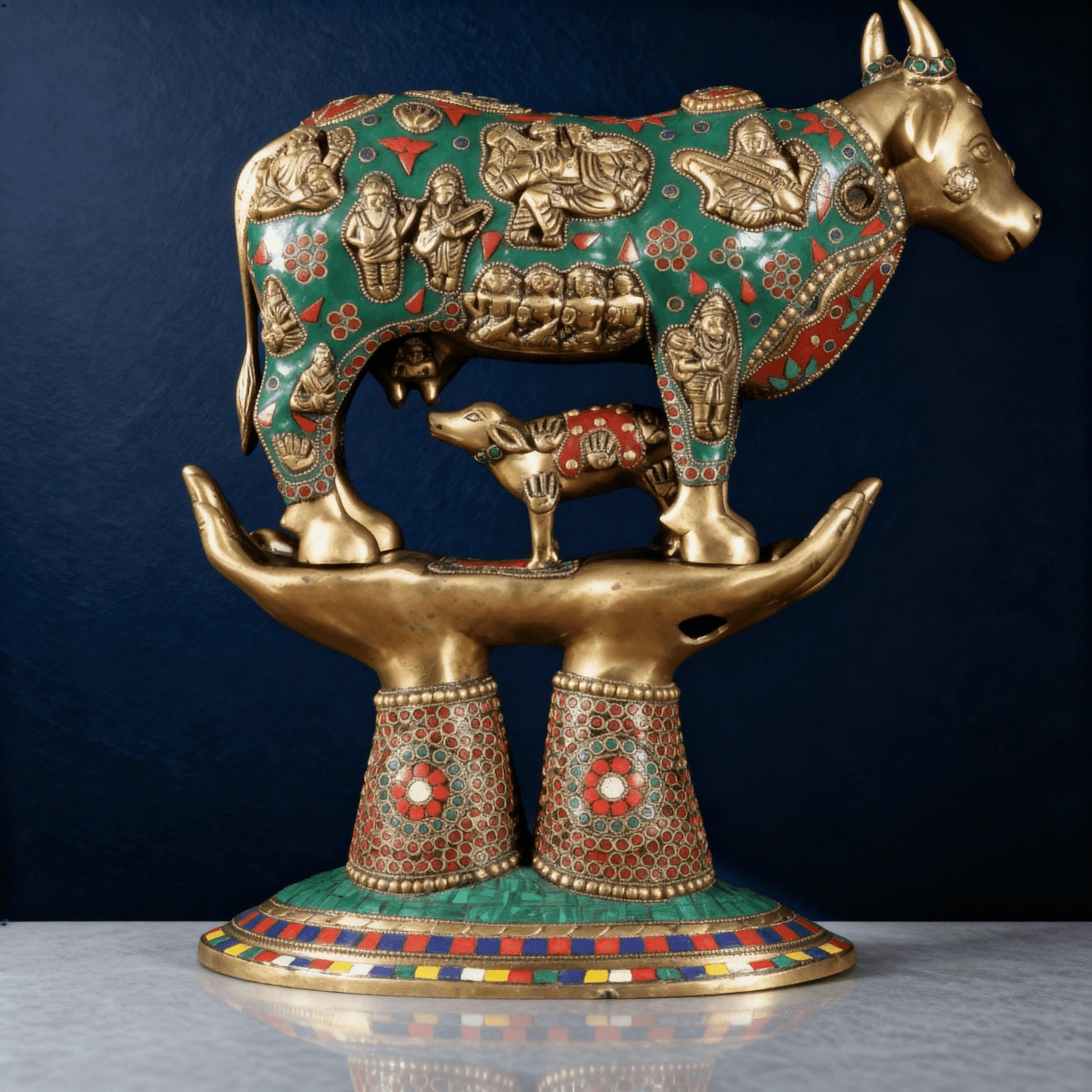 Detailed side view of brass Kamadhenu cow and calf statue on decorative hands – spiritual Indian showpiece for gifting