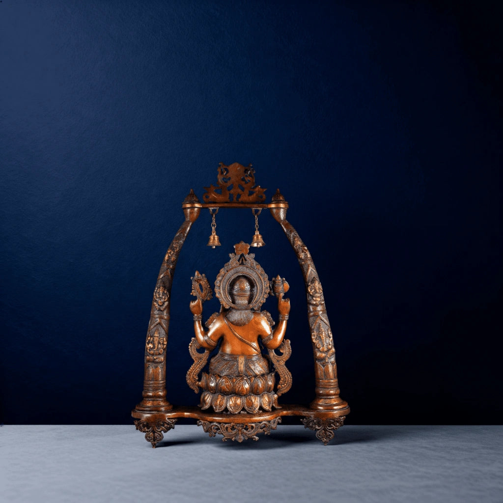 Handcrafted brass Ganesh swing idol with ornate arch and bells on a dark blue background