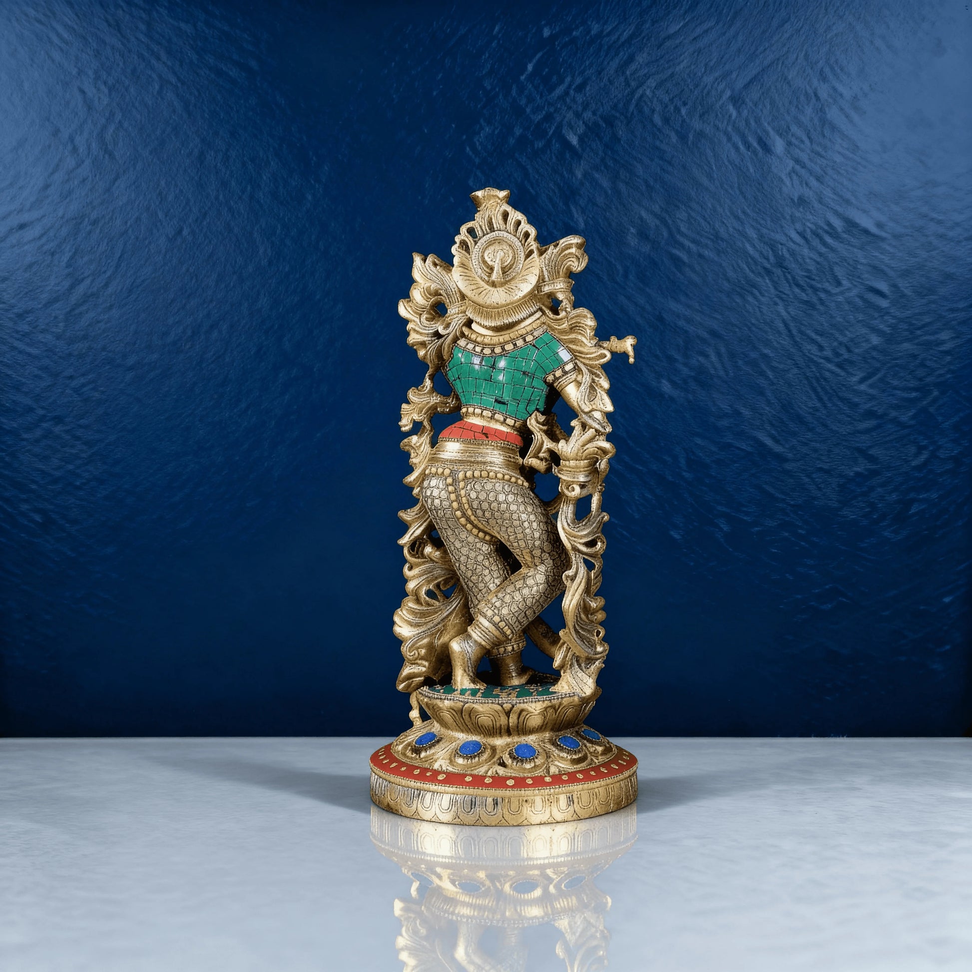 Back view of Krishna brass statue with embossed detailing, traditional patterning, and colorful handwork on clothing and base