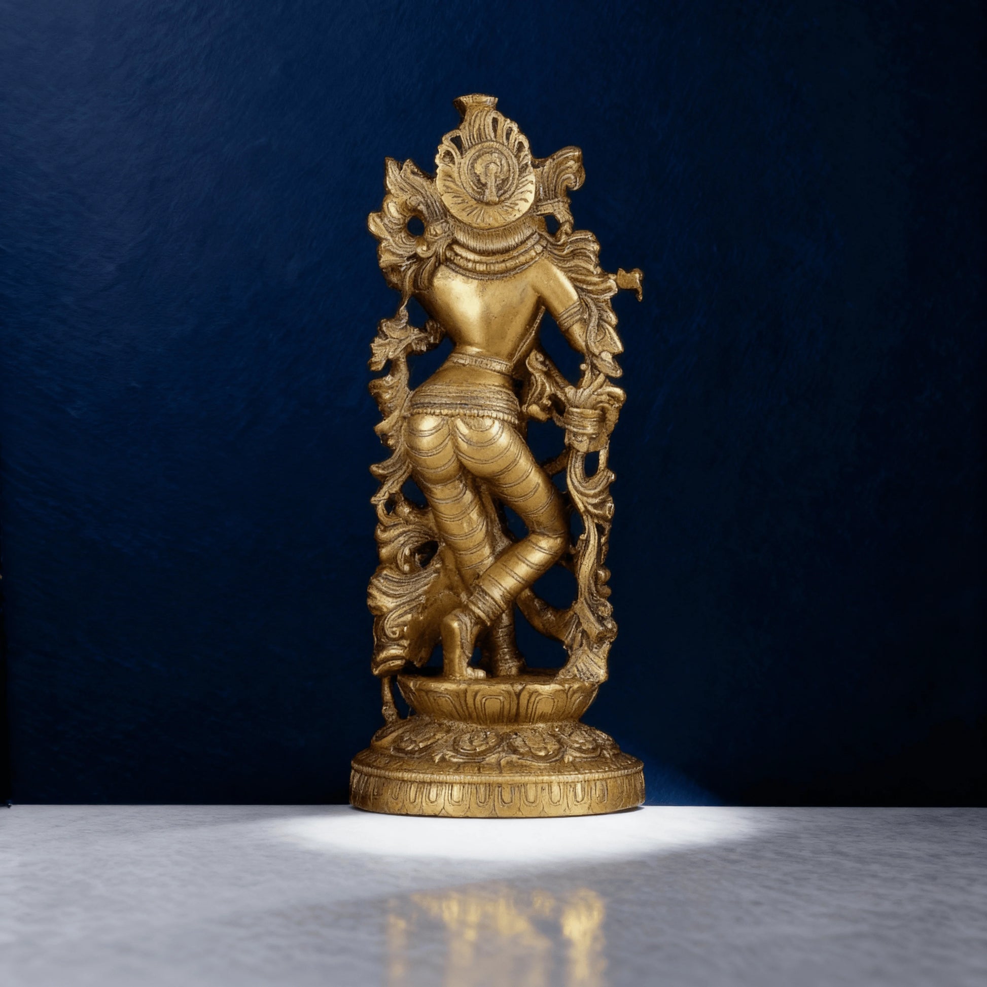 Rear view of Krishna idol in brass, detailed handwork on traditional drape and back panel