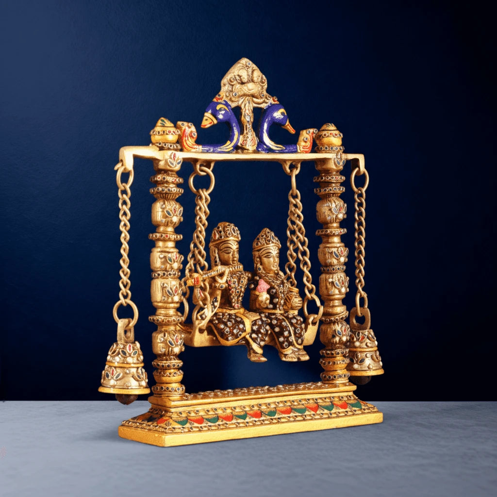 Handcrafted brass Radha Krishna Jhula with meenakari artwork, peacock arch detailing and decorative hanging bells on swing frame
