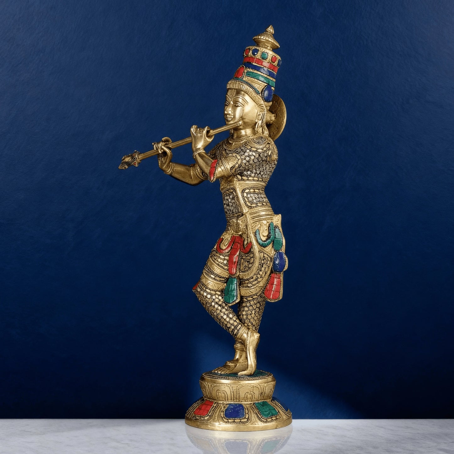 Brass Krishna idol playing flute with colourful meenakari stonework on pedestal