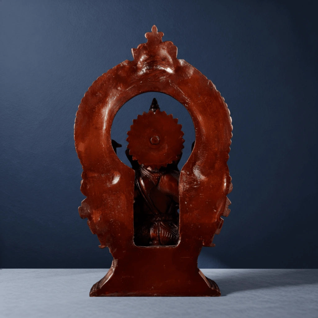 Rear side of brass Ganesha idol showing carved halo arch and traditional sculpting work