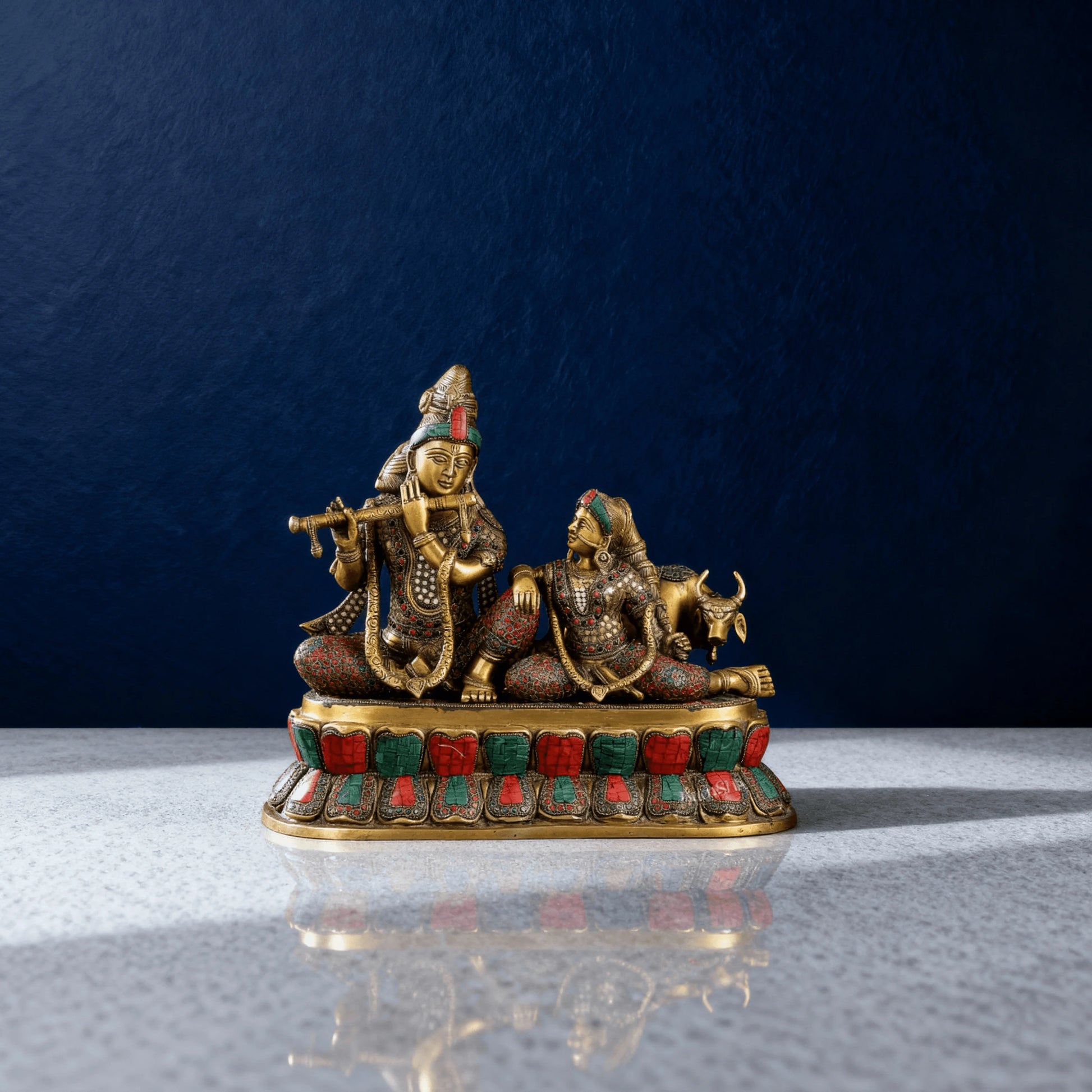 Full frontal image of brass Radha Krishna with intricate stone detailing, seated on ornamental base