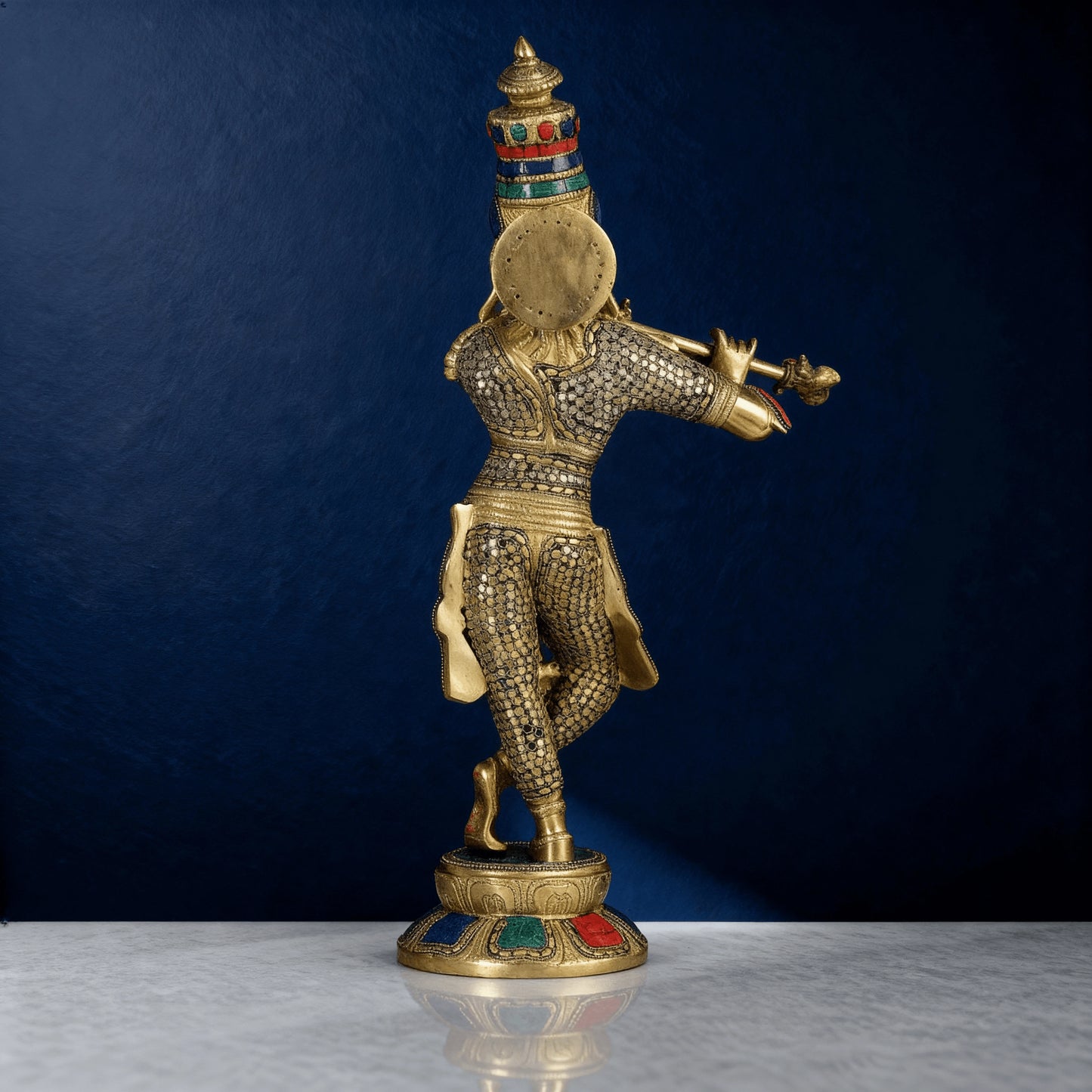 Rear view of brass Krishna statue with intricate carvings and enamel detailing