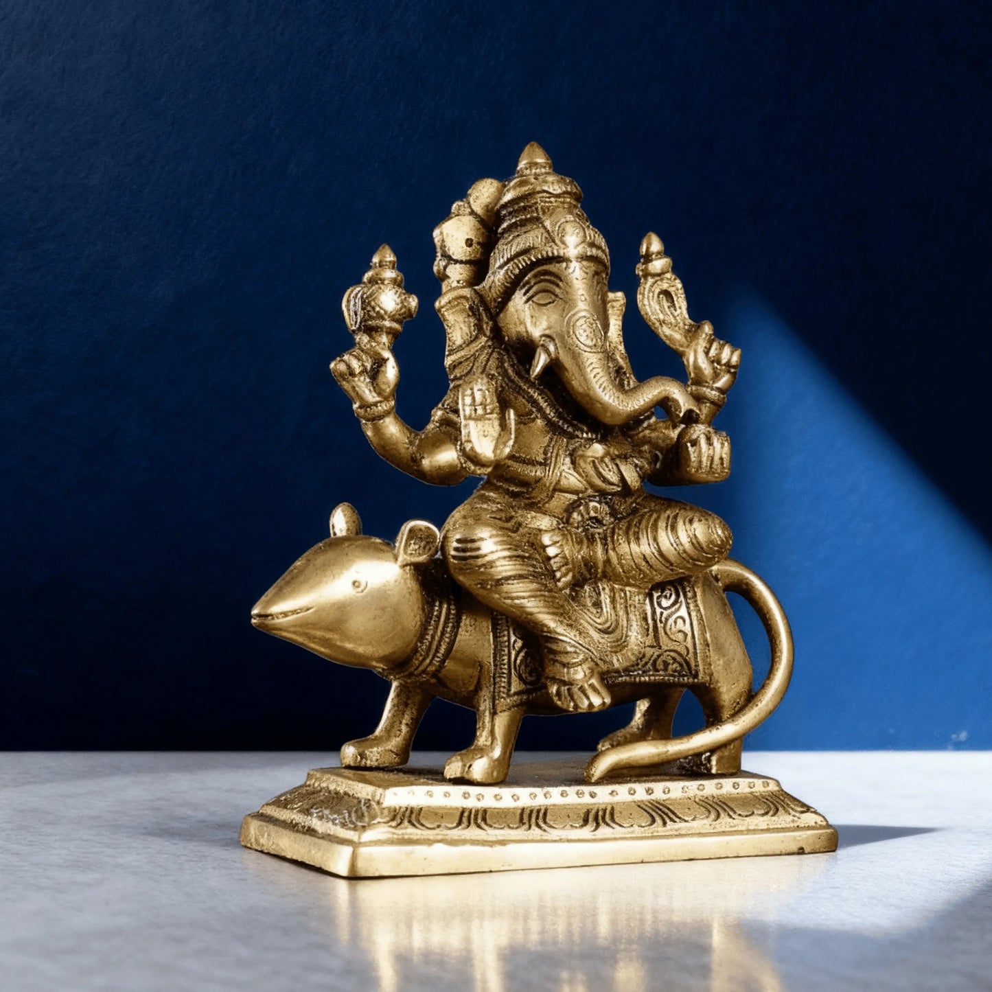 Handcrafted brass Ganesha seated on mouse vahana three quarter view