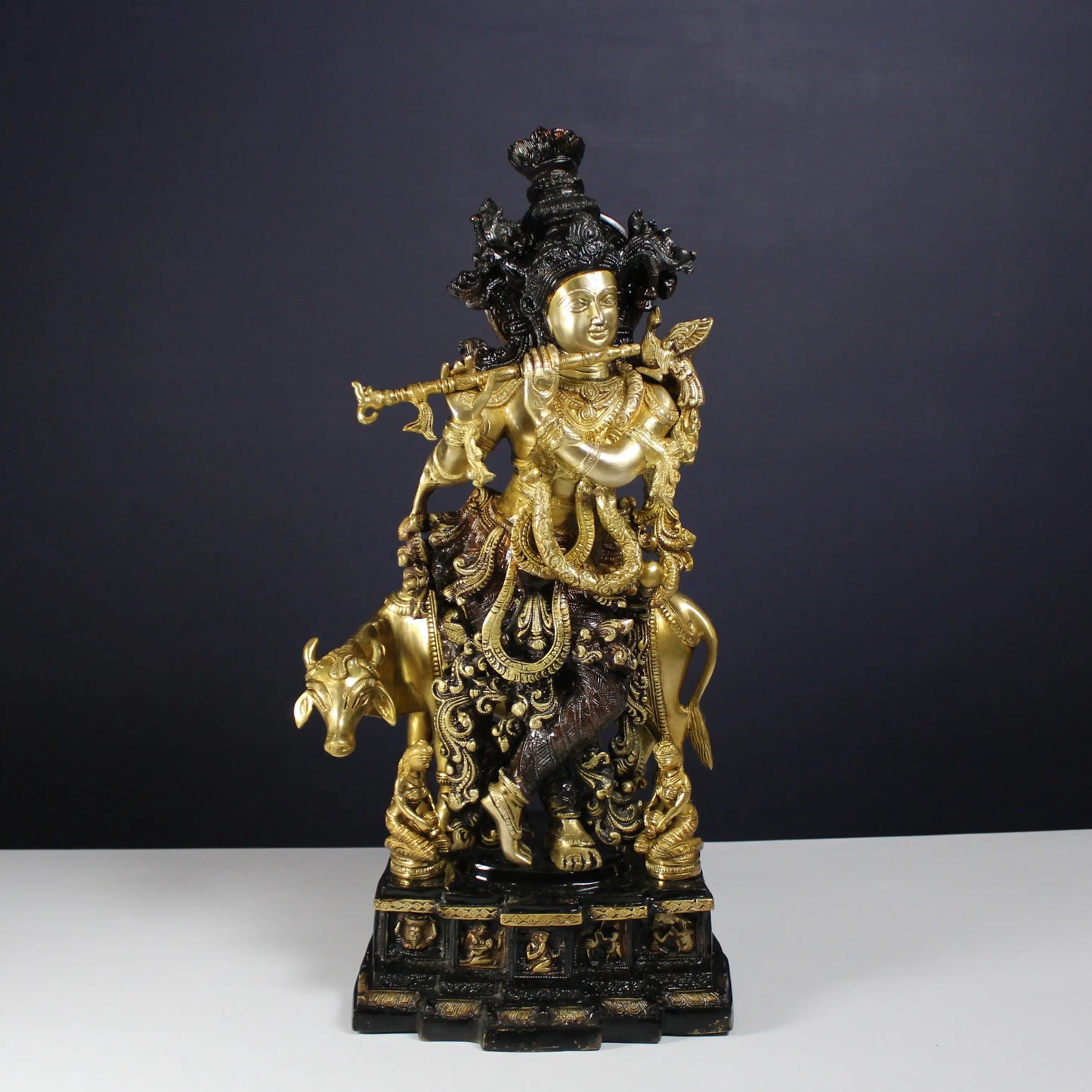 Decorative Krishna statue of a figure on a bull with intricate details against a dark background
