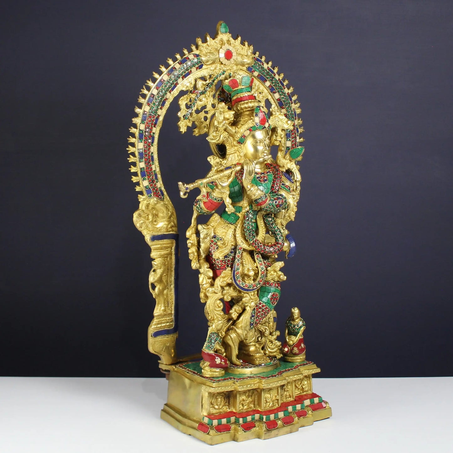 krishna statue with gold and multicolor elements on a dark background