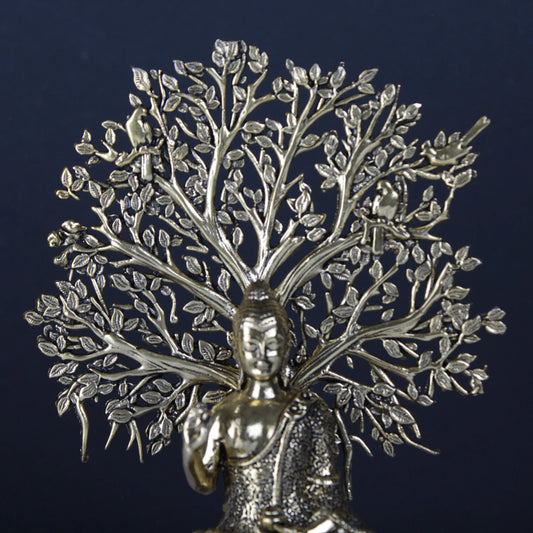 Metallic tree sculpture with a central figure against a dark background