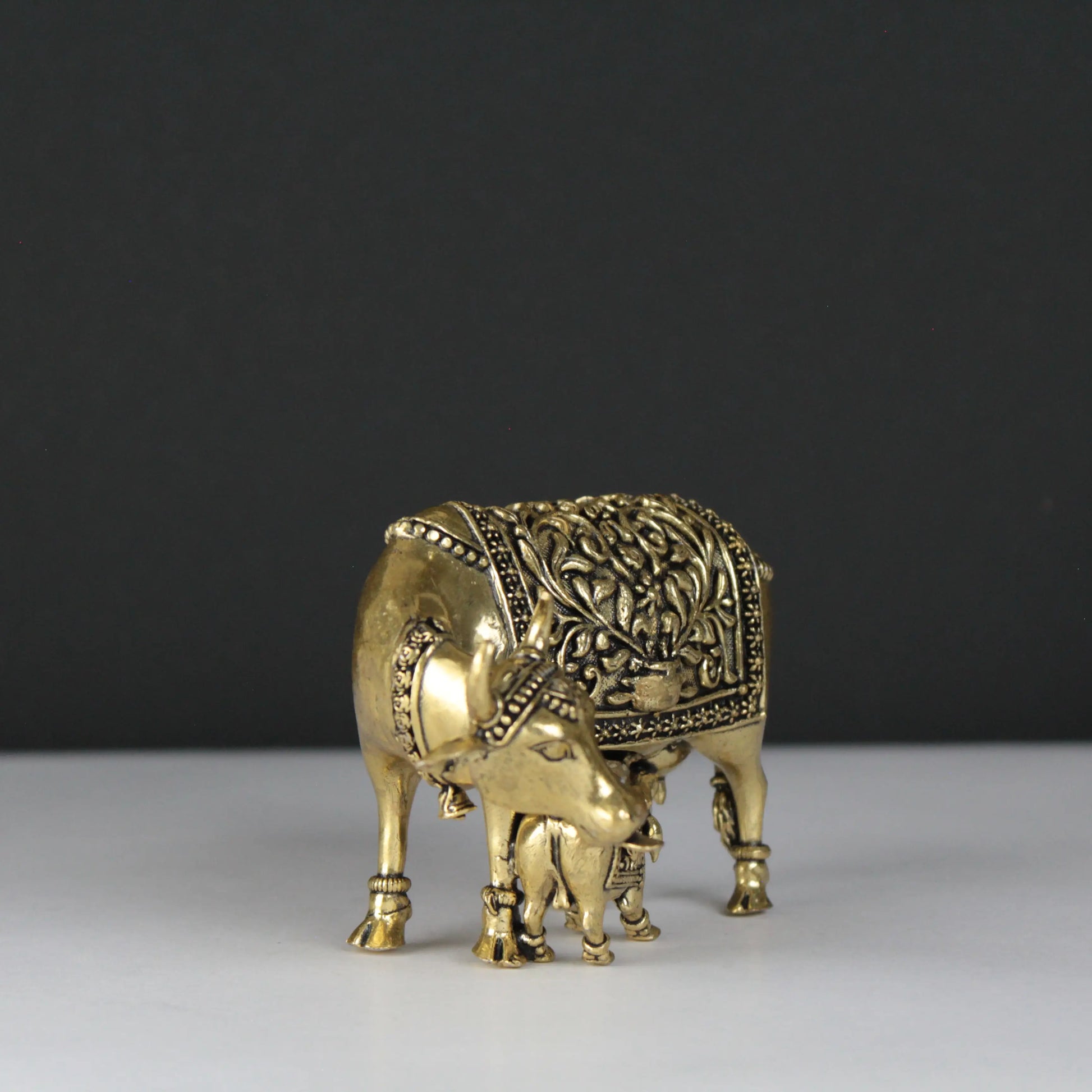 Decorative brass bull figurine on a plain background