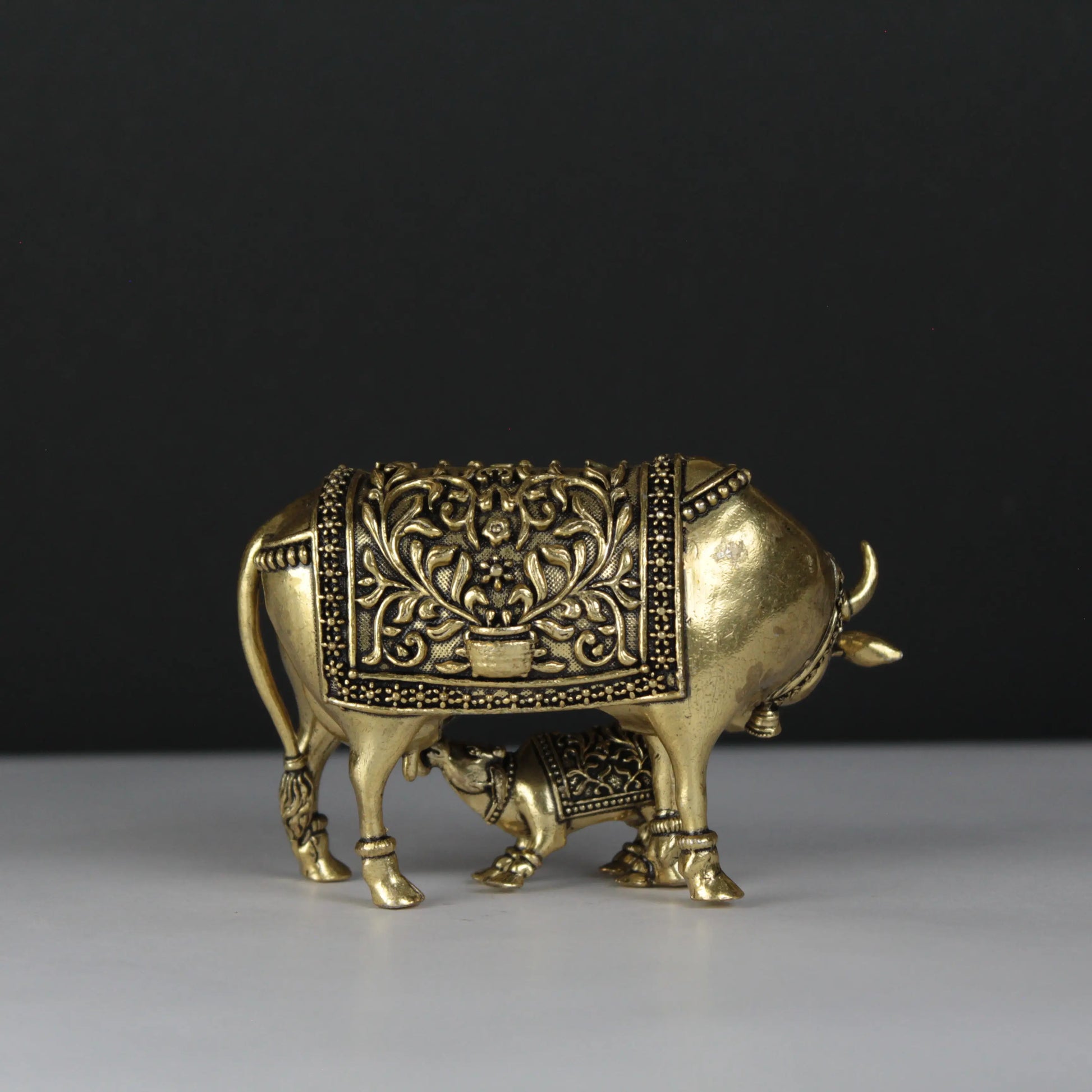 Decorative brass bull figurine on a black background