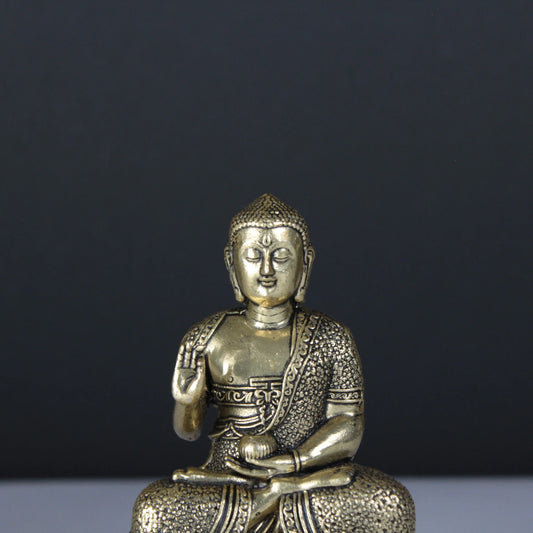 Brass Buddha statue on a dark background