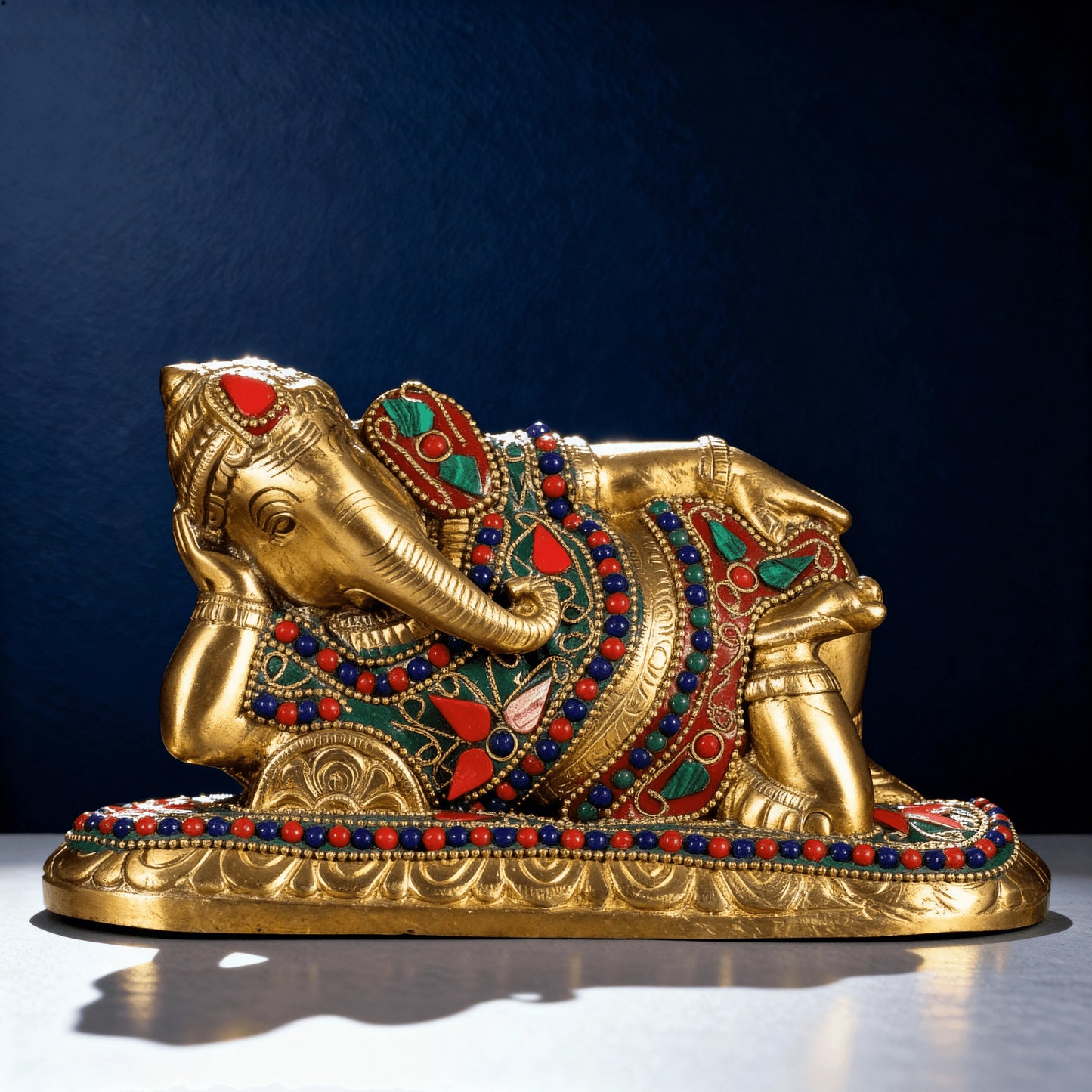 close up reclining ganesha brass murti detailed stone carving