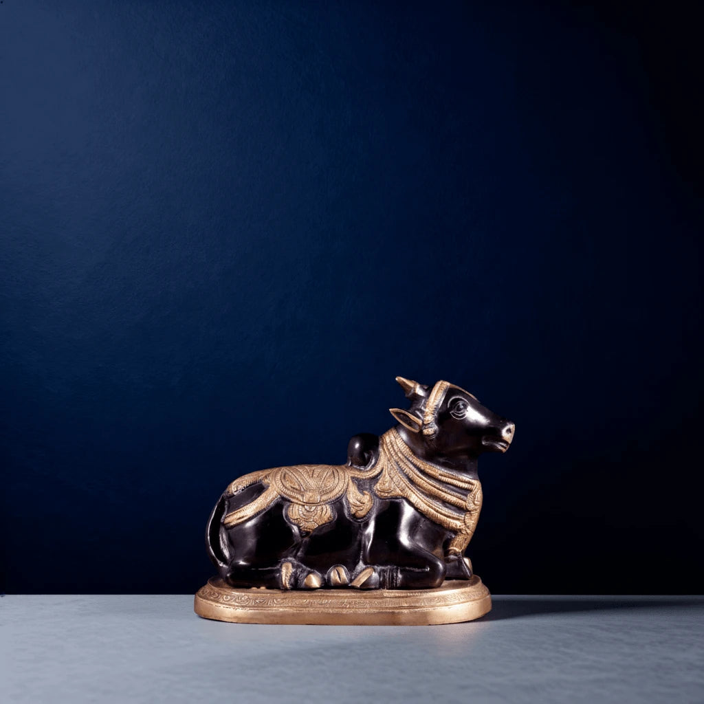 Small black and gold Nandi statue photographed in studio lighting