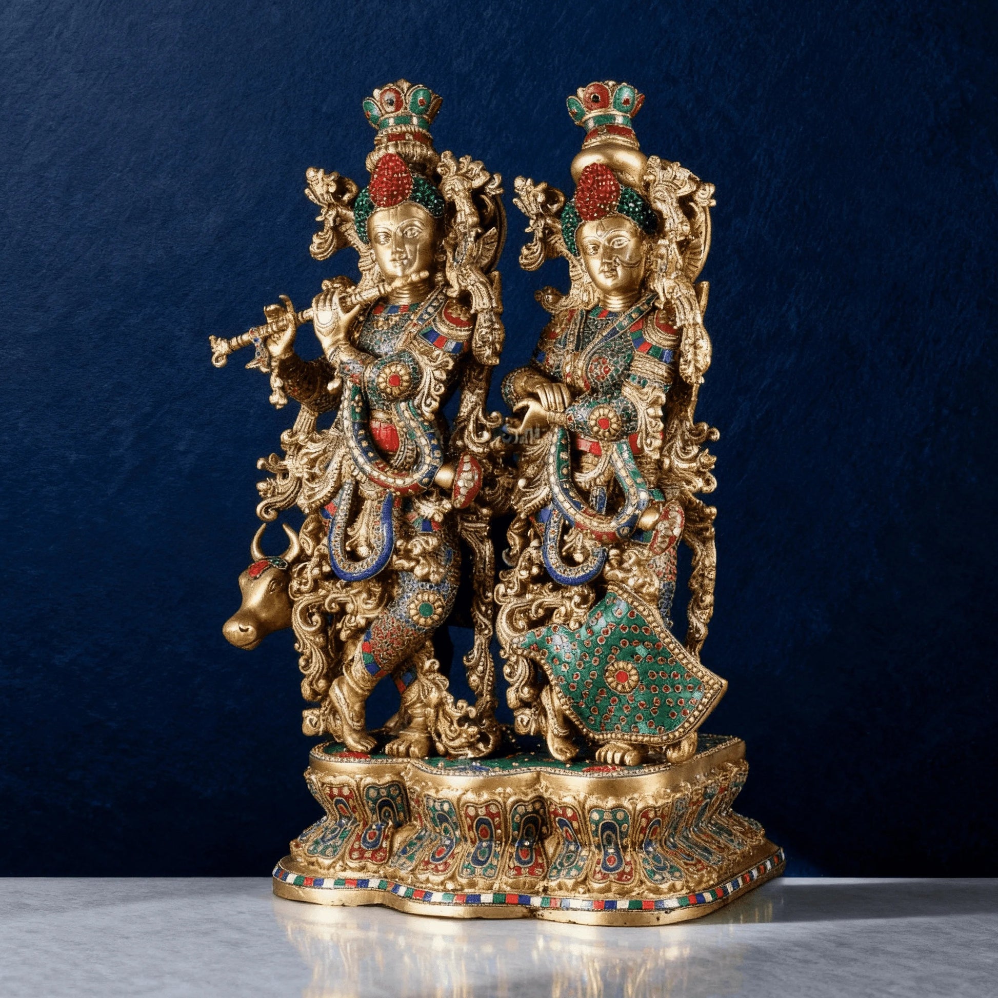 Full-height brass Radha Krishna idol with cow, ornate design, multicolored accents, placed on marble surface.