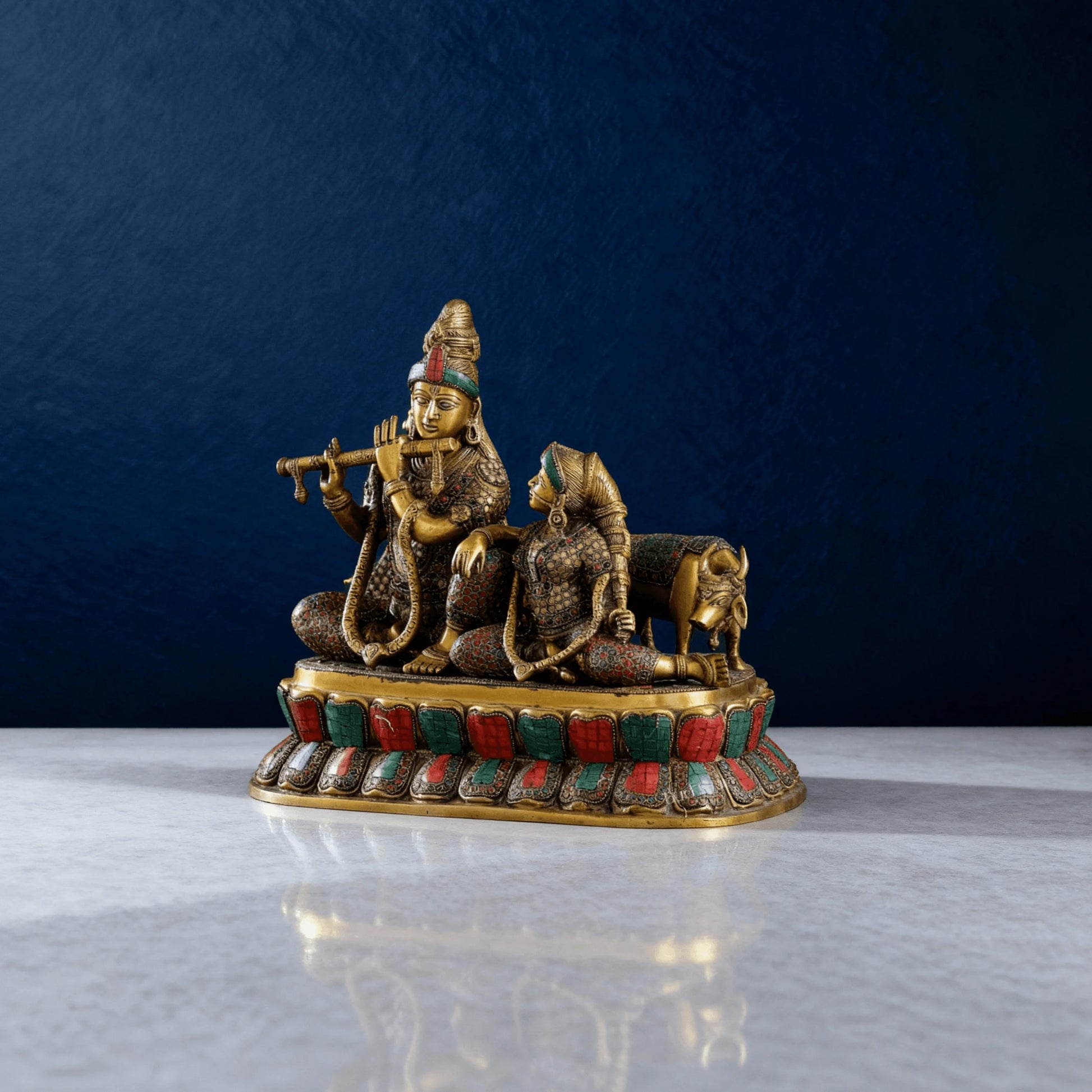 Side angle view of brass Radha Krishna sculpture showing craftsmanship and inlay work with cow