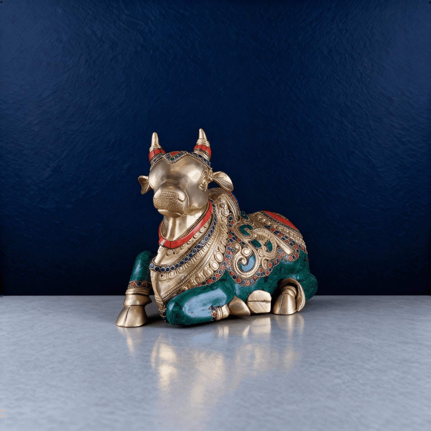 Front view of sitting brass Nandi statue featuring intricate gemstone work and antique detailing, handcrafted by Aarvya artisans.