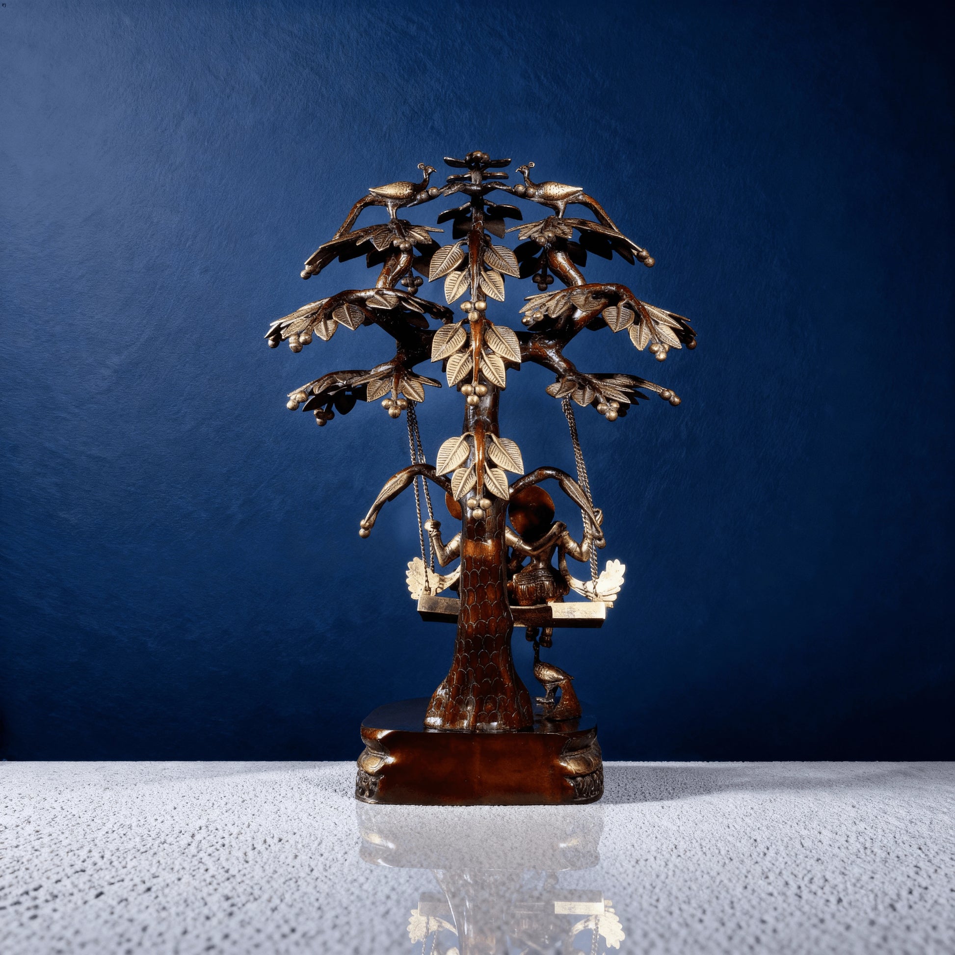 Back view of brass Radha Krishna jhula statue with carved tree design