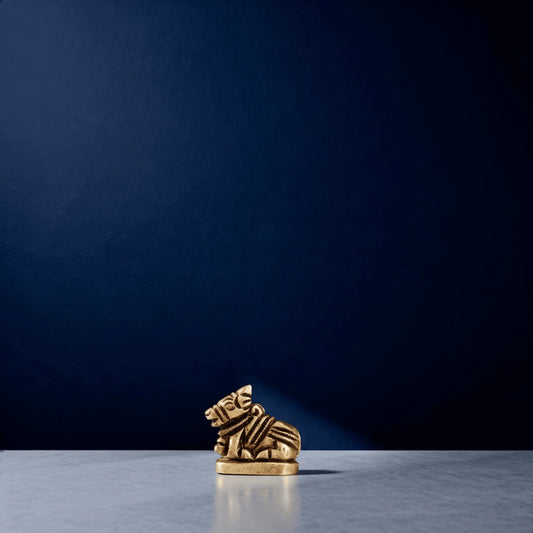 Tiny handcrafted brass Nandi statue under a soft spotlight in a studio setup