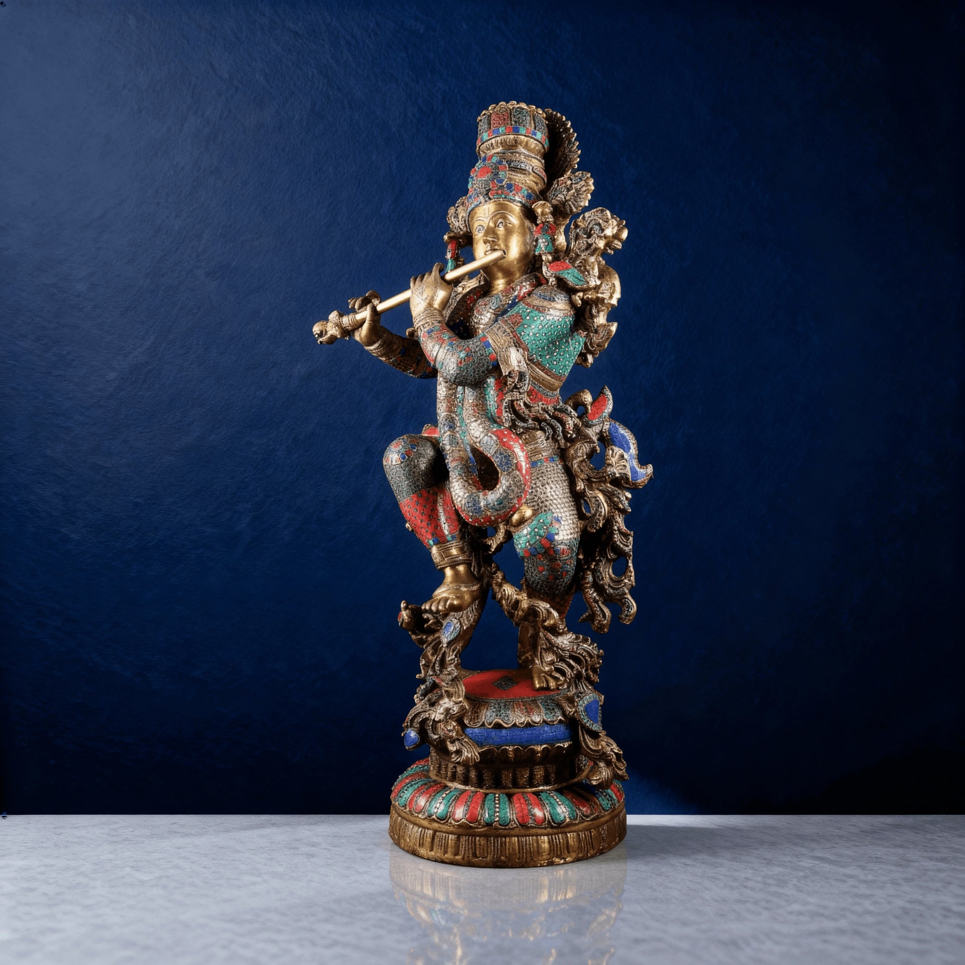 Tall brass Krishna statue with intricate red-green-blue stonework
