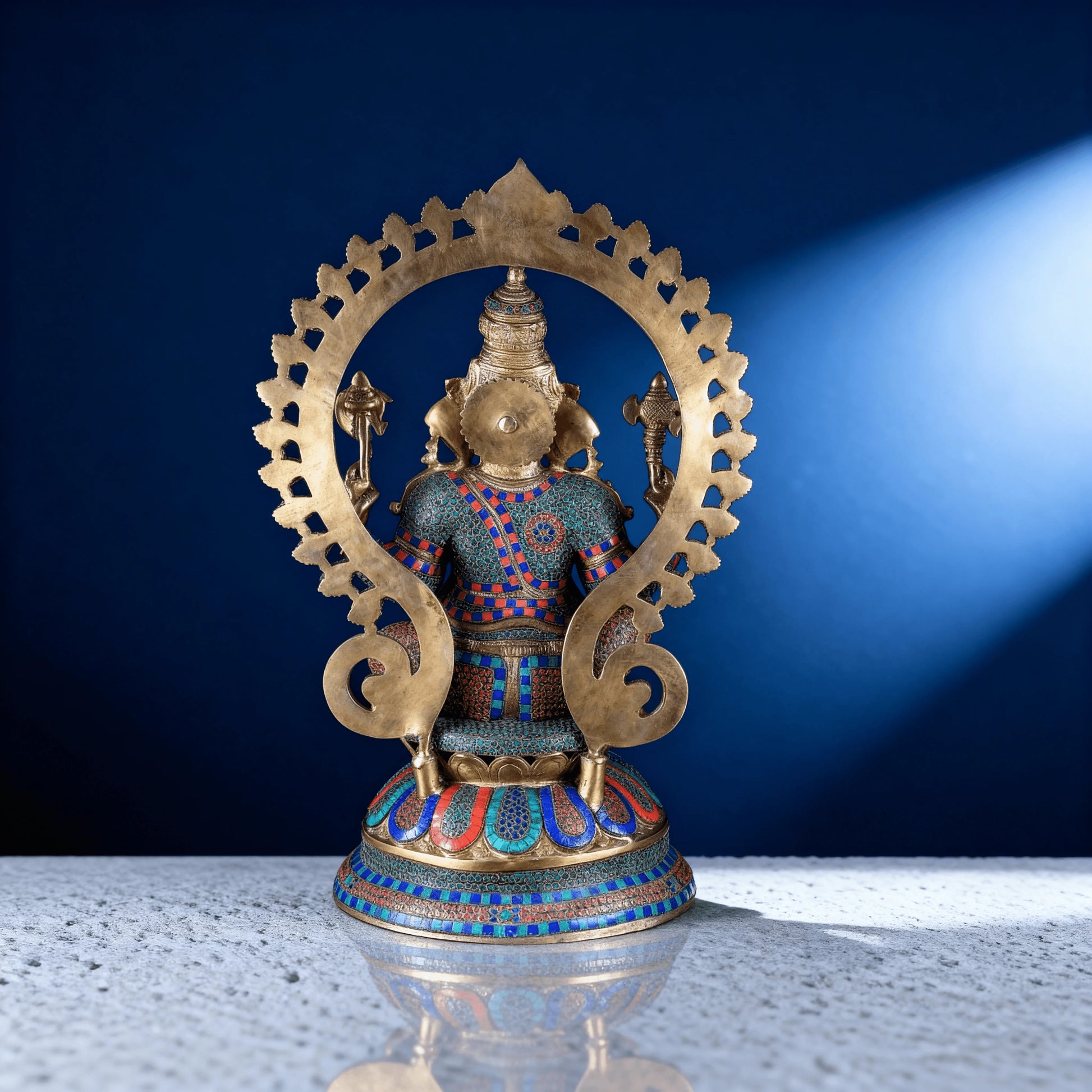 Back view of meenakari brass Ganesha statue showing detailed craftsmanship, stonework patterns, and decorative halo
